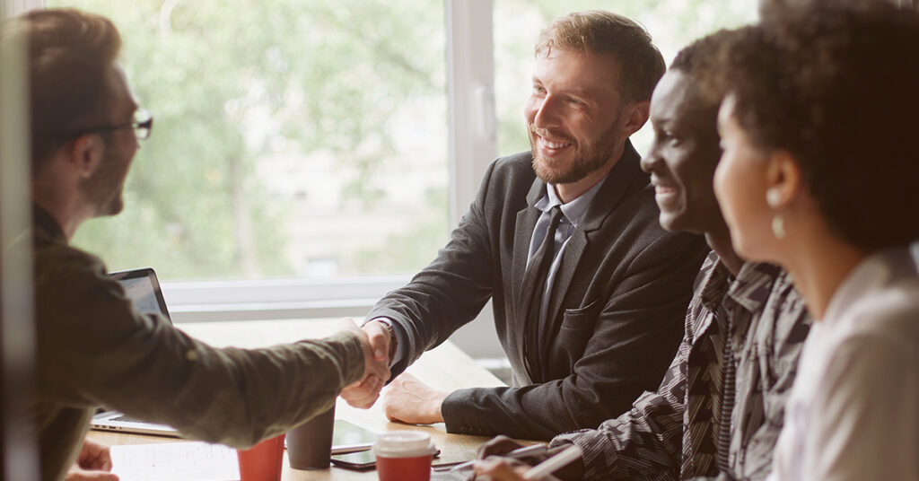 business-people-greet-each-other-at-the-table-after-merging-brands